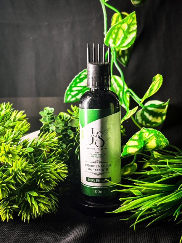 Rosemary hair oil among fresh leaves